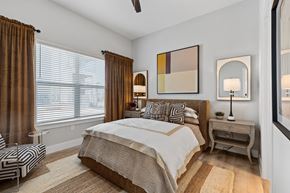 Hickory Creek apartment for rent - A bedroom with a large bed and a ceiling fan.