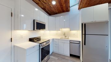 San Francisco apartment for rent - A modern kitchen with white cabinets and a wooden ceiling.