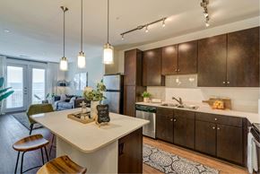 Austin apartment for rent - A kitchen with a white island and brown cabinets.