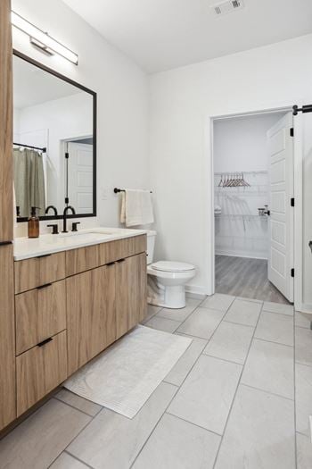 Spacious en-suite primary bathroom with quartz countertops, shower, tub tile surrounds, and frameless glass shower doors*