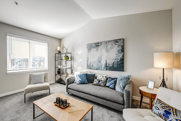 Fife apartment for rent - A living room with a grey couch, a wooden coffee table, and a large painting on the wall.