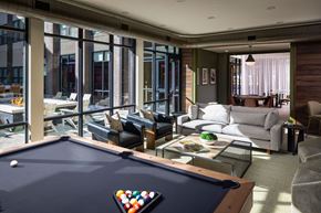 Oklahoma City apartment for rent - A pool table with a white ball on it is in the middle of a room with a couch and chairs.