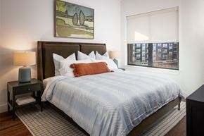 Oklahoma City apartment for rent - A bedroom with a large bed and a painting on the wall.
