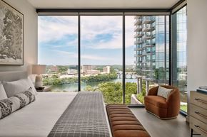 Austin apartment for rent - A bedroom with a large bed and a view of the city.