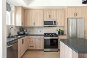 Montclair apartment for rent - A kitchen with wooden cabinets and a black countertop.