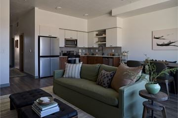 Vineyard apartment for rent - A living room with a green couch and a coffee table with a book on it.