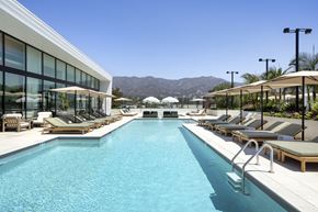Burbank apartment for rent - A large outdoor swimming pool with sun loungers and a mountain in the background.