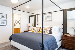 Murray townhouse for rent - A bedroom with a four poster bed and a nightstand with a lamp.