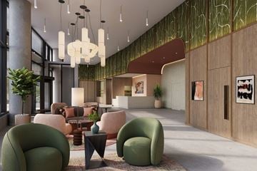 Nashville apartment for rent - A modern living room with green chairs and a large chandelier.