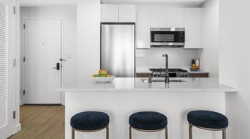 New Rochelle apartment for rent - A kitchen with a white counter and a refrigerator.