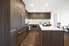 Washington apartment for rent - A modern kitchen with wooden cabinets and a marble backsplash.