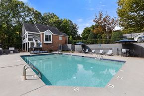 Cary apartment for rent - A large swimming pool with a house in the background.