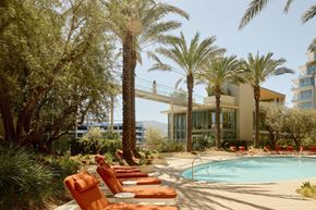 San Marcos apartment for rent - A pool surrounded by orange chairs and palm trees.