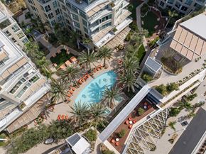 San Marcos apartment for rent - An aerial view of a pool surrounded by palm trees and orange chairs.