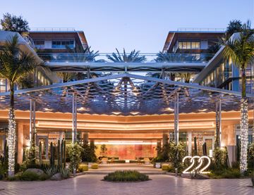San Marcos apartment for rent - A modern building with a large glass entrance and a canopy over it.