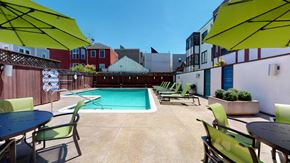 San Francisco apartment for rent - a pool with green chairs and umbrellas on a sunny day