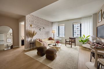 Jersey City apartment for rent - A living room with a white sofa and a brown armchair.