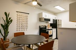 Albuquerque apartment for rent - a dining area with a table and chairs and a kitchen in the background