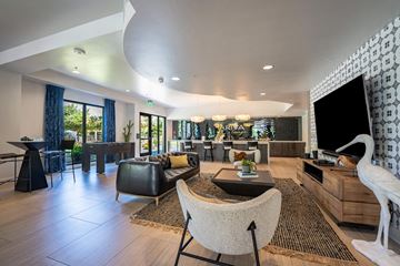 San Diego apartment for rent - A living room with a black leather chair and a white chair with a patterned cushion.