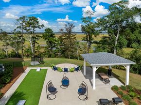 Charleston apartment for rent - A covered patio area with a table and chairs overlooking a grassy field.