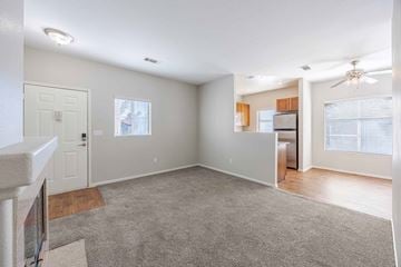 Las Vegas apartment for rent - A spacious living room with a grey carpet and a ceiling fan.