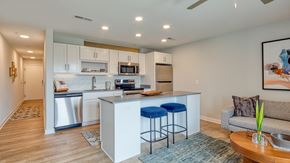 Richmond apartment for rent - A modern kitchen with a bar stool and a couch.