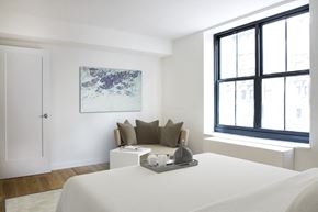 New York apartment for rent - a bedroom with a bed and a couch and a large window