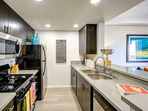 Long Beach apartment for rent - A modern kitchen with a black stove top oven and a black refrigerator.