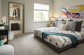 Denver apartment for rent - A bedroom with a large bed and a painting on the wall.