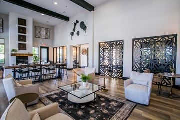 Las Vegas apartment for rent - A living room with a glass coffee table and white chairs.