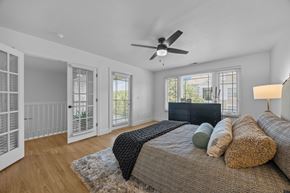 Asheville apartment for rent - A bedroom with a bed, pillows, and a ceiling fan.