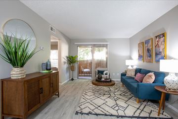 Phoenix apartment for rent - A living room with a blue couch and a wooden cabinet.