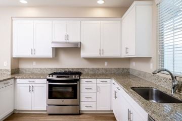 San Diego apartment for rent - a kitchen with white cabinets and a granite counter top