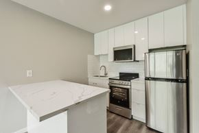 San Francisco apartment for rent - a white kitchen with stainless steel appliances and a marble counter top