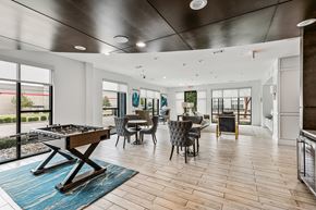 Dallas apartment for rent - A modern dining room with a pool table and a view of the outside.