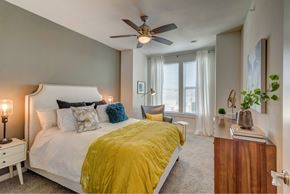 Austin apartment for rent - A bedroom with a white bed and a yellow comforter.