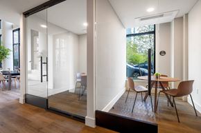 Jersey City apartment for rent - A private work booth featuring a table and chairs with glass walls.