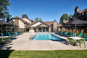 Vancouver apartment for rent - a swimming pool with blue chaise lounge chairs and umbrellas