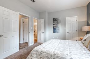 Fairburn apartment for rent - A bedroom with a large bed and a painting on the wall.