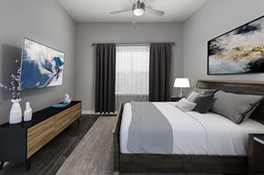 Orlando apartment for rent - A modern bedroom with a large bed and a television on the wall.
