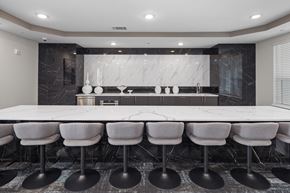 Apex apartment for rent - Conference room with a long white tables, chairs, and a kitchen area in the back.