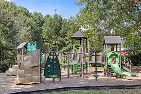 Rolesville apartment for rent - A playground with a green slide and a brown structure.