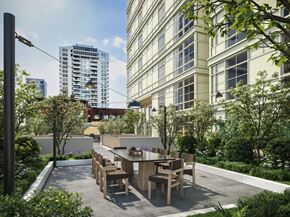 Seattle apartment for rent - A modern outdoor dining area with tables and chairs surrounded by greenery.