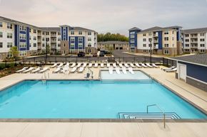 Waldorf apartment for rent - A large swimming pool surrounded by sun loungers and apartment buildings.