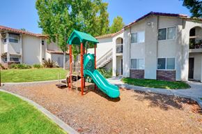 La Mesa apartment for rent - A playground with a green slide in front of apartment buildings.