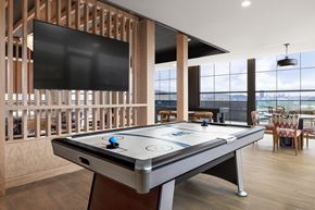 Pittsburgh apartment for rent - A pool table with a black cloth and white felt is in the center of the room.