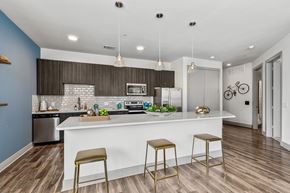 Dallas apartment for rent - A kitchen with a white counter and bar stools.