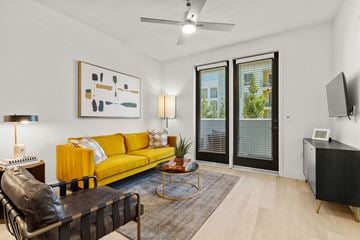 Sacramento apartment for rent - A living room with a yellow sofa and a black leather chair.