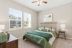 San Antonio apartment for rent - A bedroom with a bed, nightstand, and window.