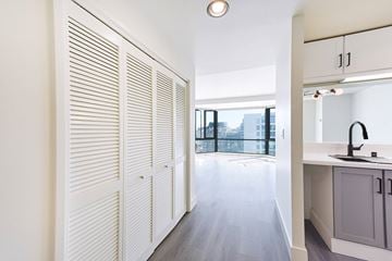 San Francisco apartment for rent - A kitchen with white cabinets and a window with blinds.